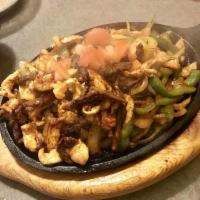 Fajitas · Served on a sizzling skillet with green pepper and onions also served with rice, beans, guac...
