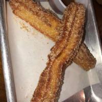 Churros · Traditional Mexican crispy pastry. Home-made fresh dough, coated in cinnamon sugar, served w...
