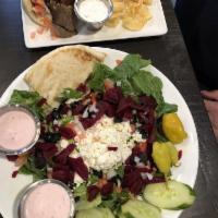 Greek Salad · Leafy greens topped with cucumbers, pepperoncinis, olives, feta cheese,  onions, tomatoes, a...