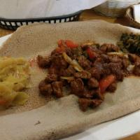 Lamb Tibs · Ethiopian's bread (injera). Lean lamb cubes sauteed with onion and jalapeno with two sides o...