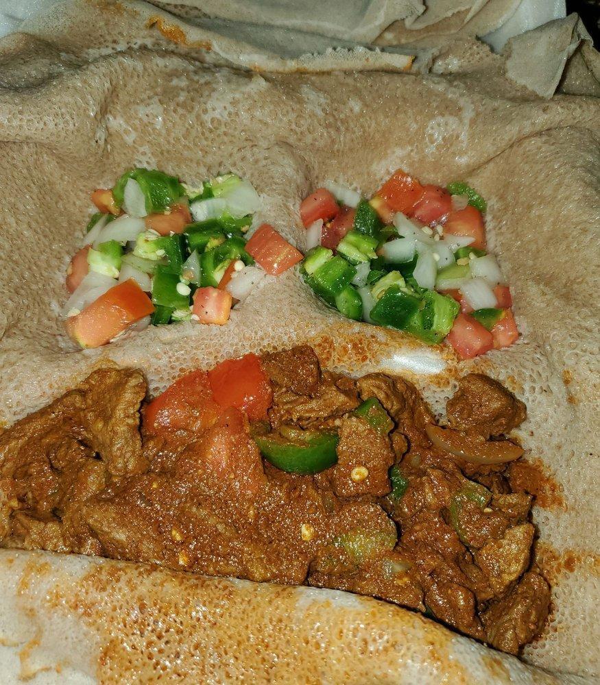 Ahadu's Beef Tibs · Ethiopian's bread (injera). Lean cubes of beef sautéed with onion, tomato, and awaze (herbed red pepper sauce). With 2 sides of veggie