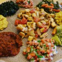 Chicken Tibs · With Ethiopian's bread (injera). Marinated cubes of chicken breast sauteed with tomato, onio...