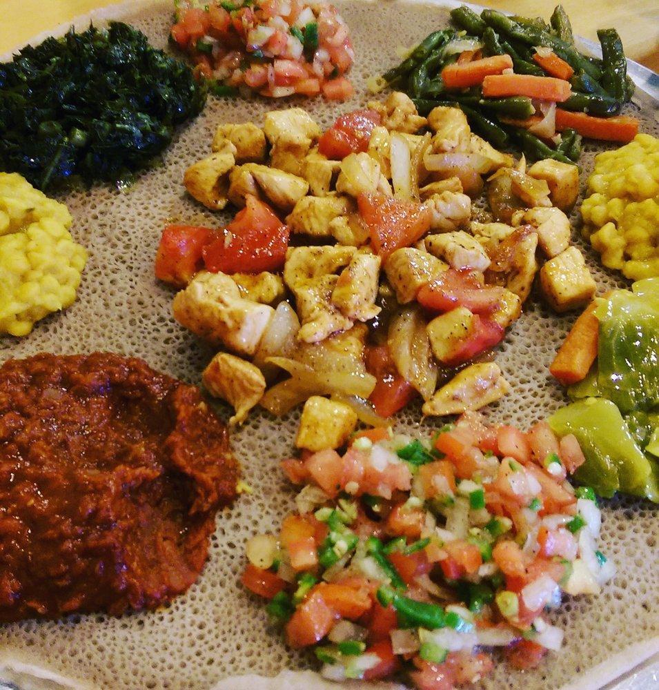 Chicken Tibs · With Ethiopian's bread (injera). Marinated cubes of chicken breast sauteed with tomato, onion, and awaze (pepper sauce) with 2 sides of veggie.