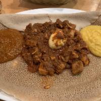 Chicken Wot · With Ethiopian's bread (injera). Cut up chicken simmered with berbere (red pepper). Served w...