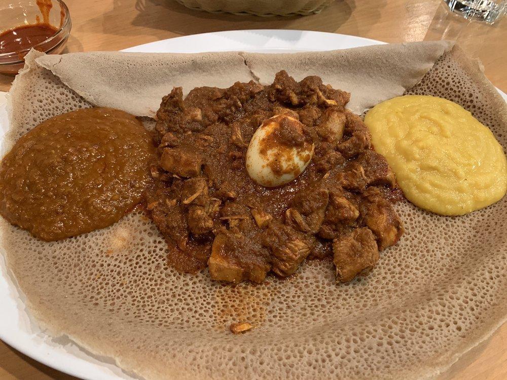 Chicken Wot · With Ethiopian's bread (injera). Cut up chicken simmered with berbere (red pepper). Served with hard boiled egg. With 2 sides of veggie.