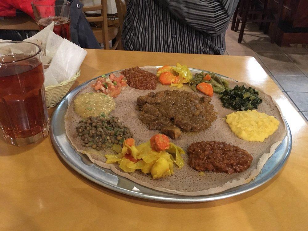 Lamb Alicha · Ethiopian's bread (injera). Lean succulent cubes of lamb simmered in an onion and ginger with 2 sides of veggie.