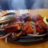 Chicken Tandoori · Chicken marinated in yogurt and mild spices and slow roasted in tandoor clay oven.