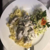 Beef Stroganoff · Italian fettuccini pasta served with broiled beef in white sauce with a side of garden salad.