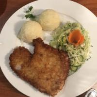 Pork Schnitzel · Pounded meat fried in light bread crumbs served with mashed potatoes and petit salad.