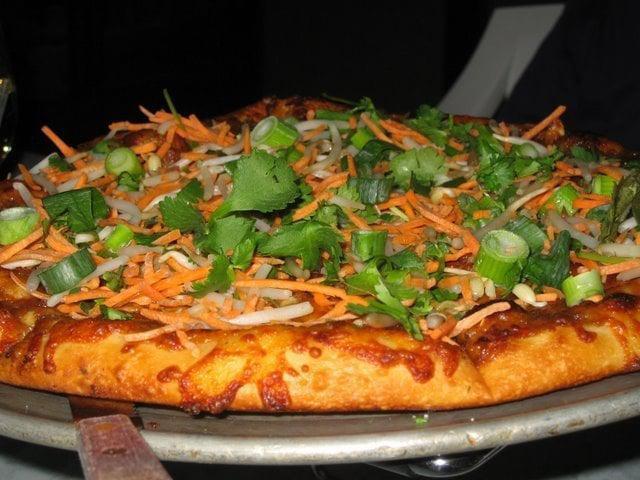 Thai Chicken Pizza · Roasted chicken, scallions, bean sprouts, shredded carrots, cilantro, peanuts and spicy peanut ginger sauce.