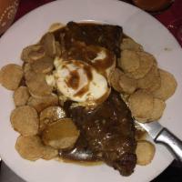 Bife a Casa · Grilled sirloin steak topped with garlic gravy and a fried egg.