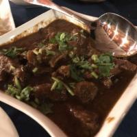 Annapurna Goat Curry · Bone-in goat meat cooked with nepalese spices – perfect company to rice or naan.