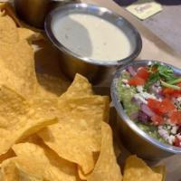 Trio · A sampling of salsa, guacamole, and queso served with chips.