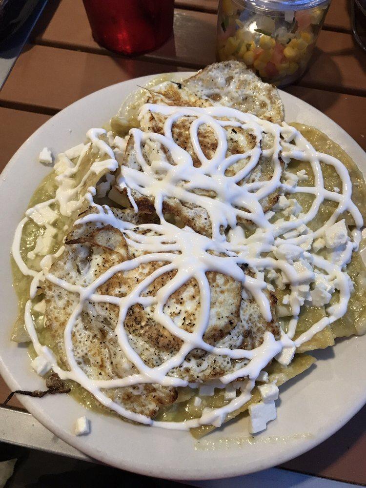 Chilaquiles · Lightly fried corn tortillas simmered in green sauce. Fried egg or choice of meat. Topped with cheese and sour cream.