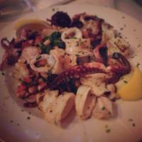 Grigliata · Grilled seafood. Marinated octopus, calamari and shrimp. Served over rapini and Tuscan beans.