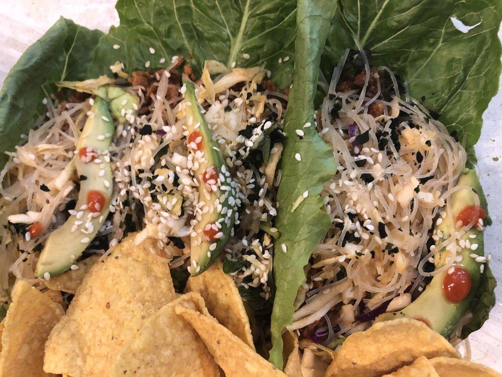 Asian Tacos · Vegan protein beef, sliced avocado, shredded cabbage, fresh
herbs, vermicelli noodles, sesame seeds, wakame seaweed, sweet
chili sauce and sriracha. Gluten free.