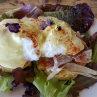 Biscuit Egg Benedict · Country ham, poached farm eggs, and house made hollandaise on a biscuit, served with baby gr...
