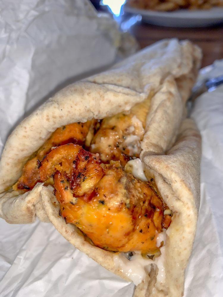 Chicken Kebab Sandwich · Charbroiled strips of chicken breast marinated in a tasty garlic lemon saffron sauce and rolled in a pita with garlic and tomatoes. Served with choice of side.