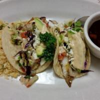 Fish Tacos · 2 fish tacos on homemade corn tortillas drizzled with mango chipotle sauce and topped with a...