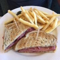 Hot Corned Beef Sandwich · Piled high on rye bread. Served with a kosher dill pickle spear and french fries.