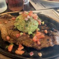 Carne Aguacatala · 10 oz. grilled center cut NY strip steak, served with white rice, tostones, guacamole and sa...
