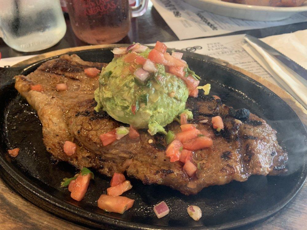 Carne Aguacatala · 10 oz. grilled center cut NY strip steak, served with white rice, tostones, guacamole and salad.