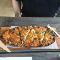 The BBQ Pulled Pork Pizza · Seasoned beer-braised pulled pork, caramelized onion, cheddar and jack cheese.
