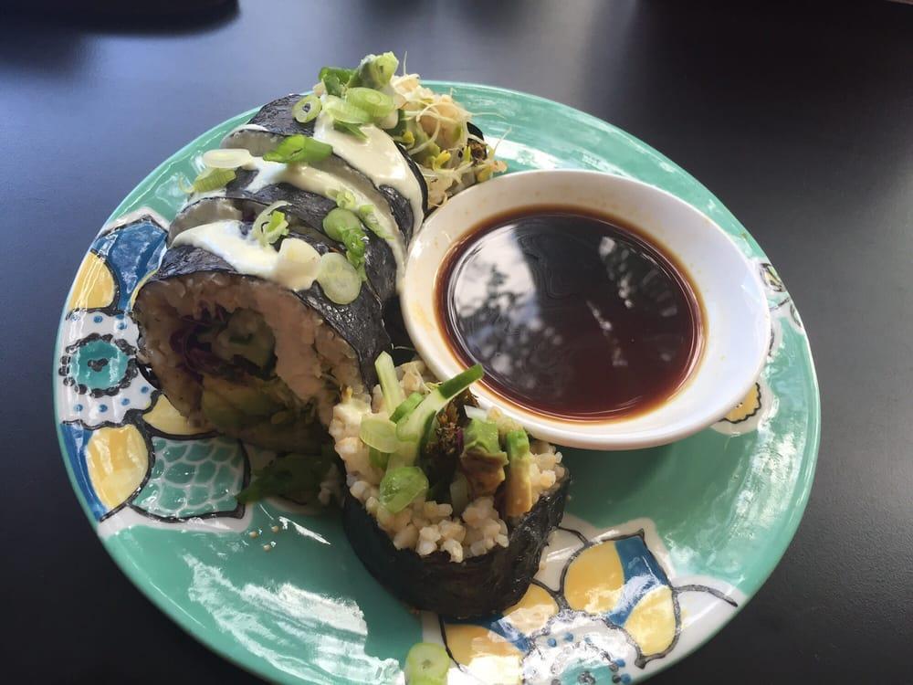 Avocado Roll · Cooked brown rice, avocado, cucumber, kale crumbles, red cabbage and lettuce wrapped in seaweed and topped with green onion and wasabi cashew sauce comes with gluten-free tamari.