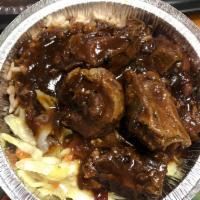 Brown Stew Chicken · Served with Rice and Peas or White Rice and Choice of Cabbage or Plantains.
