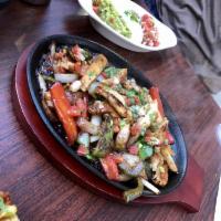 Fajita · Onions and peppers on a sizzle platter, rice, beans, guacamole, pico de gallo, crema Mexican...