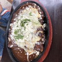 Enchiladas · A taste of Frida's signature beef enchiladas with mole poblano, white onions, queso fresco, ...