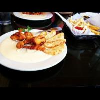 Chicken Brochette · Fried natural chicken breast wrapped in bacon on Gorgonzola cream sauce, served with sliced ...