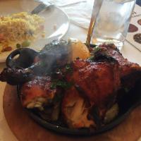 Tandoori Chicken · Marinated organic quarter legs cooked in clay oven and served hot skillet with caramelized o...