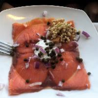 Smoked Salmon Carpaccio · Thinly-sliced smoked salmon topped with lemon dill cream cheese, capers, red onions. Served ...