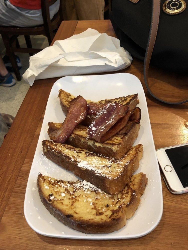 Brioche French Toast · Buttery brioche bread dipped in spiced custard and grilled, finished with powdered sugar. Served with applewood-smoked bacon.