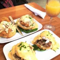 Eggs Cochon · Apple-braised pork debris served over a buttermilk biscuit, topped with two poached eggs and...