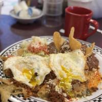 Chilaquiles · Corn tortillas cut in quarters and lightly fried, with green salsa, refried beans, Monterey ...