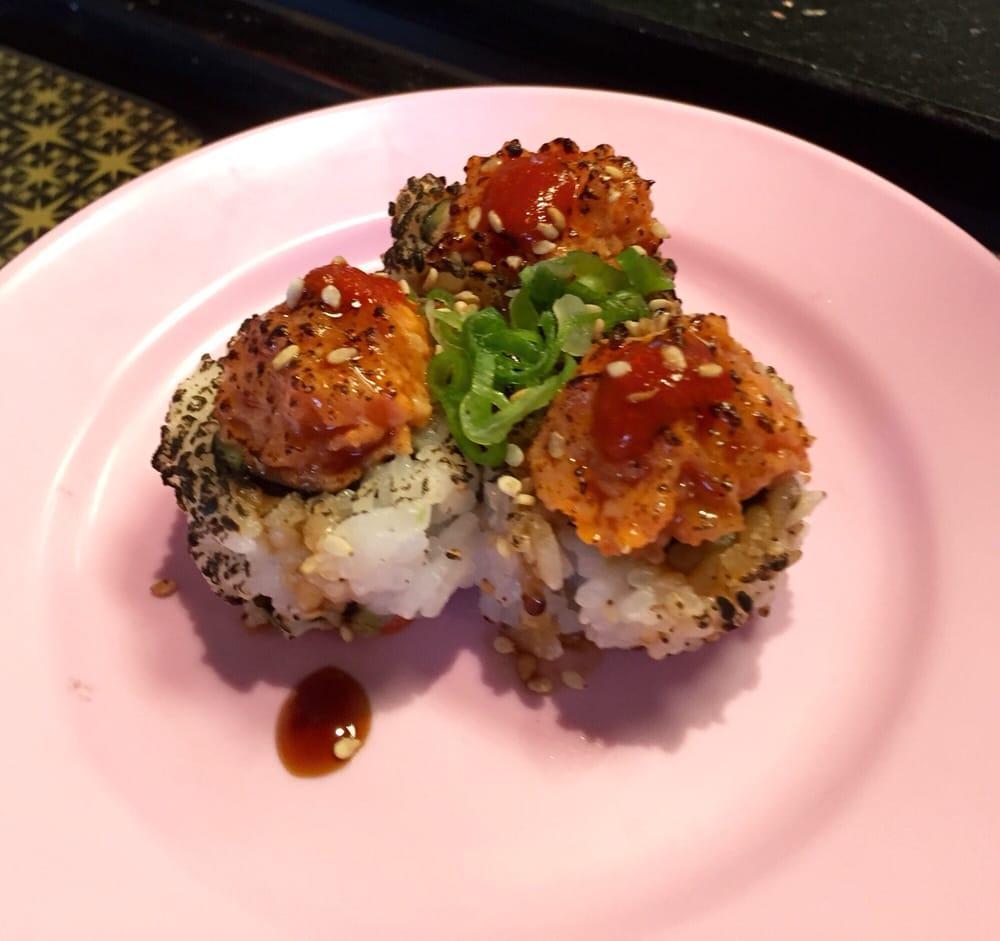 Volcano Roll · 8 pieces. California roll base with seared spicy salmon on top torch and teriyaki sauce, sriracha, green onion.