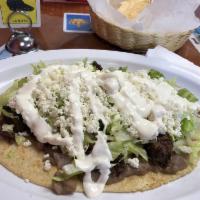 Huaraches · Oval flat fried dough topped with choice of meat, lettuce, queso fresco, sour cream, refried...
