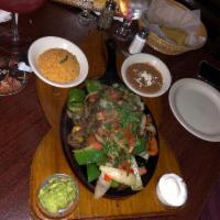 Steak Fajitas · Steak, shrimp and chicken. Sizzled in a succulent white wine marinade with onions, peppers a...