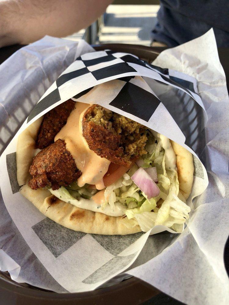 Falafel Gyro · Chickpea patties deep fried to golden perfection. Served in a warm pita with lettuce, tomato, onion, pickles, and tahini sauce. Made vegan.

Add optional Spicy Garlic, Feta Cheese and Hummus with some curly fries to complete your meal.