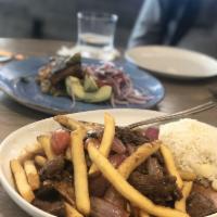 Lomo Saltado · Wok seared tenderloin, soy and oyster sauce, onions, tomato petals, jasmine rice, fries