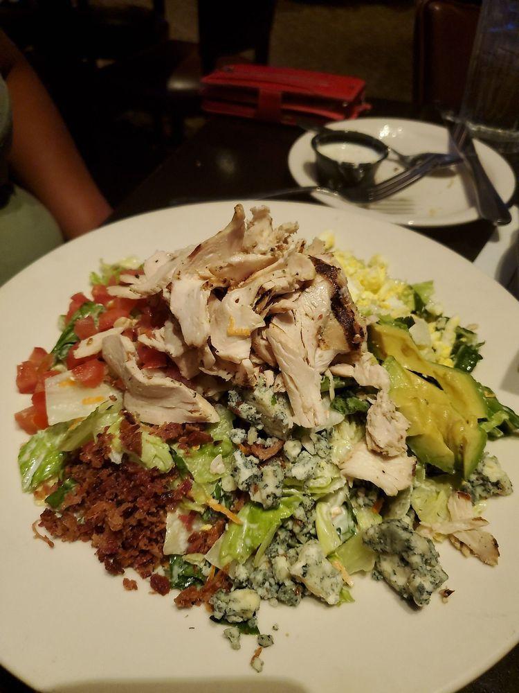Chopped Cobb Salad · Garden greens, grilled chicken, Avocado, Crisp bacon, Diced Egg, tomatoes, Blue cheese crumbles, Homemade Blue cheese dressing.