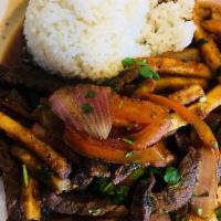 Lomo Saltado · Beef tenderloin strips with sauteed red onions and tomatoes. Served with white rice and fren...
