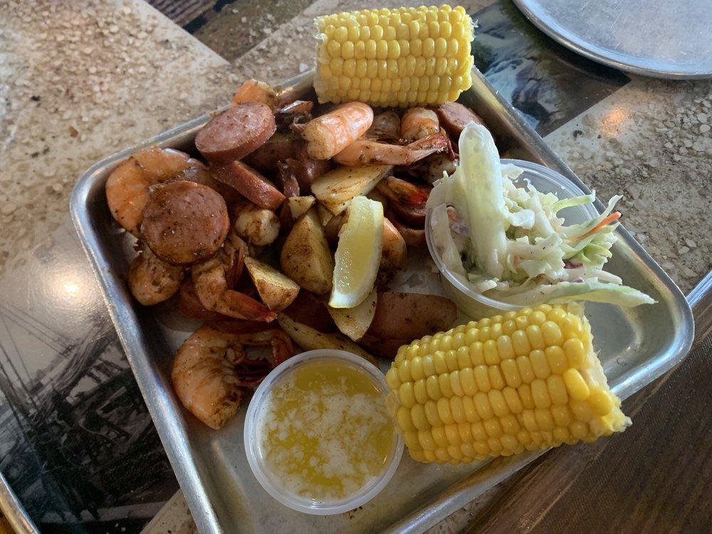 Low Country Boil · 1/2 lb. shrimp, sausage, potatoes, corn, and a side of slaw. Steamed in old bay.

