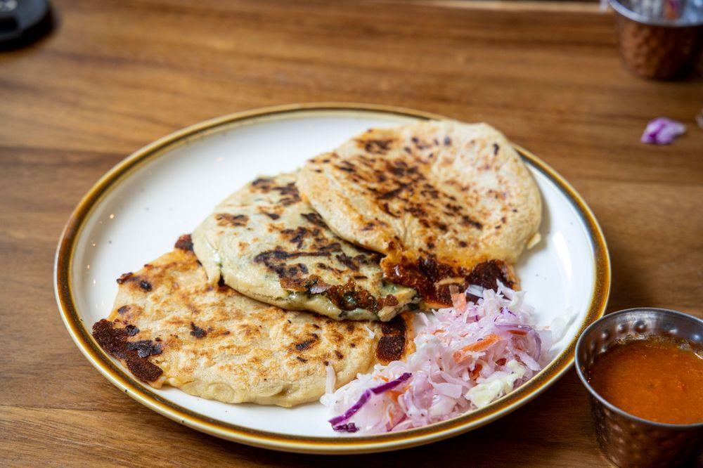 Pupusas · 3 traditional Salvadorian thick corn tortillas stuffed with your choice of savory filling, and melted mozzarella served with homemade coleslaw and salsa.