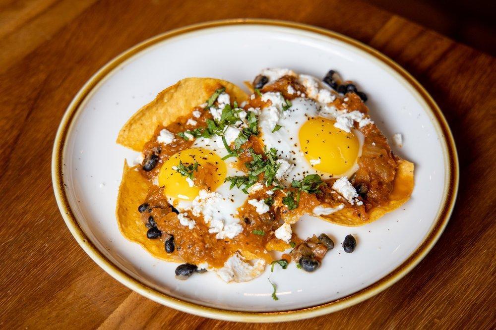 Huevos Rancheros · Crispy corn tortillas, black beans, sunny-side eggs, salsa ranchera, cheese & cilantro