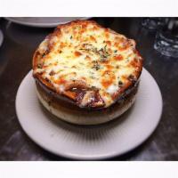 French Onion Soup · Topped with Gruyere cheese and a slice of French baguette.
