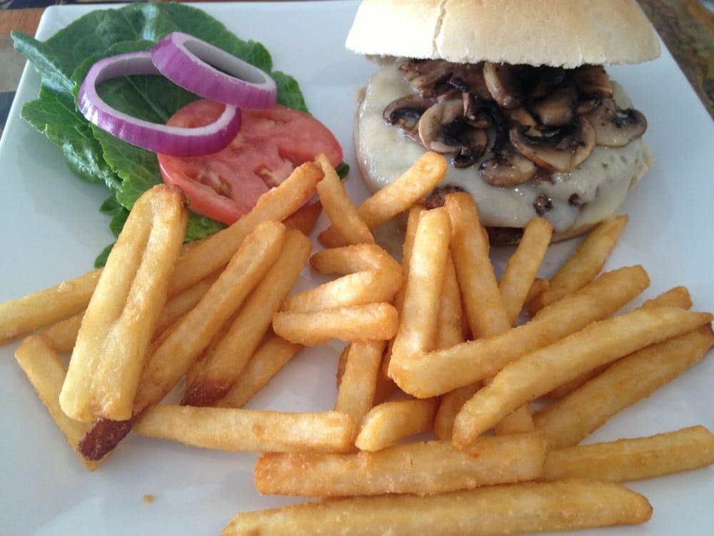 Mushroom Swiss Burger · Fresh grilled Hereford beef patty topped with sauteed mushrooms and Swiss cheese with red onion, tomato and lettuce on the side.