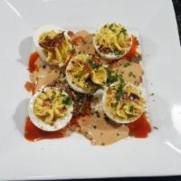 Deviled Eggs · Topped with candied bacon, chopped pecans and chipotle cream. Gluten free.